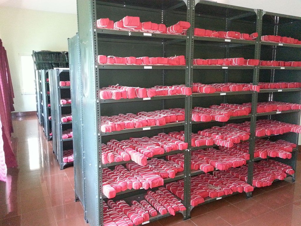 Manuscript bundles wrapped in red cloth on library shelves